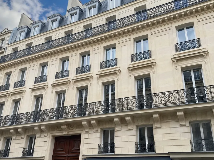 Façade d'immeuble ravalée, pierre et modénatures remises à neuf